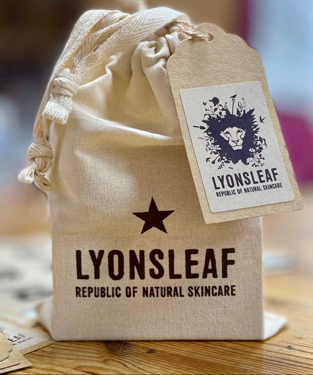 Cotton drawstring gift bag with Lyonsleaf branding on a wooden surface