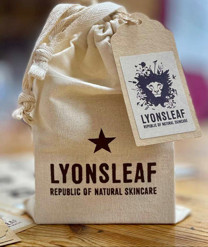 Beige drawstring bag with Lyonsleaf skincare branding on a wooden surface.