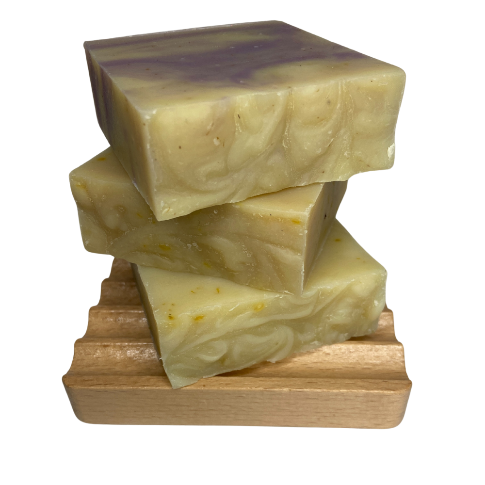 Lyonsleaf cedarwood and lavender soap bars stacked on a  wooden soap dish
