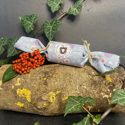 Lyonsleaf Christmas cracker skincare on a log surrounded by ivy and berries